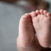 Baby feet in white bed. Selective focus.